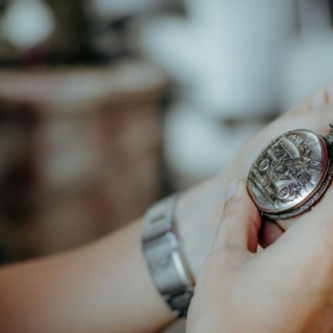 A close-up image of a person holding a vintage pocket watch, possibly symbolizing inheritance or sentimental items passed down after a deceased person’s estate is settled—relevant in the context of an insolvent estate where not all assets may be distributed to family members
